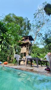 un complejo con una casa en el árbol y una piscina en Treegana en Triganá