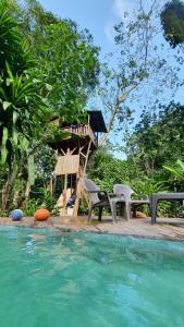 un complexe avec une cabane dans les arbres et une piscine dans l'établissement Treegana, à Triganá