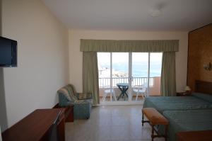 a bedroom with a bed and a balcony with a view at Hotel Altariño in Portonovo