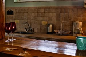 a kitchen counter with two glasses of wine on it at Cabañas Cascada Escondida in El Bolsón