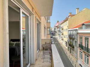 un balcón con sillas y mesas en una calle de la ciudad en Claude Homes Lisbon Rato, en Lisboa