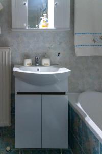 een badkamer met een witte wastafel en een bad bij Grigo apartments in Alexandroupoli +41 foto's