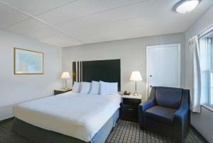 una camera d'albergo con letto e sedia di Motel 6 Washington, PA a Washington