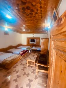 a room with two beds and a table in it at Taimoor Hotel swat Kalam in Kalām