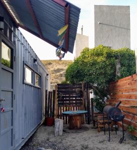 eine Terrasse mit einem Tisch und einer Bank neben einem Gebäude in der Unterkunft El Trotamundos in Puerto Pirámides