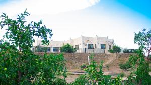 un edificio sentado en la parte superior de una pared de piedra en فيلا الشفا الجبلية Al Shafa Villa en Al Shafa