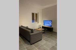 ein Wohnzimmer mit Sofa und Fernseher in der Unterkunft Maison de charme in Montagnac