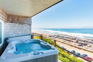 een hot tub op een balkon met uitzicht op het strand bij Seagull Beachfront Inn in Lincoln City