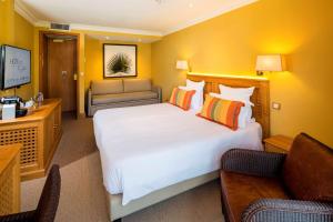 Best Western Premier Montfleuri في سانت ماكسيم: غرفة فندقية بسرير كبير واريكة