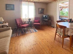 uma sala de estar com cadeiras, uma mesa e uma televisão em 4 person holiday home in VETLANDA em Vetlanda