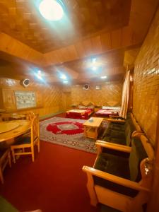 a room with a bed and a table and chairs at Riverside Hotel Kalam in Kārandūkai