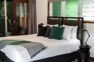 a bed with a white comforter and pillows at Daintree Ecolodge in Daintree