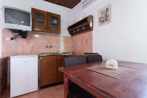 a kitchen with a table and a tv on the wall at One-Bedroom Apartment in Kukljica I in Kukljica +18 photos