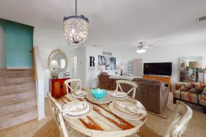 een eetkamer en een woonkamer met een houten tafel en stoelen bij Paradise in the Palms in Mexico Beach