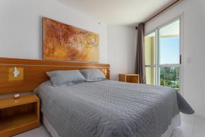 1 dormitorio con cama y ventana grande en Flat na Praia do Pontal com vista deslumbrante - Villa del Sol Residences, en Río de Janeiro