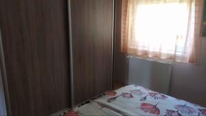 Cama en habitación con ventana y colcha en Apartment in Balatonmariafürdo 19297, en Balatonmáriafürdő