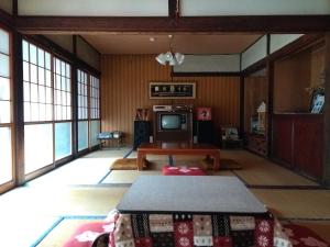 a living room with a table and a tv at Akiu Canada 鴻の巣温泉 Konosu Onsen in Sendai