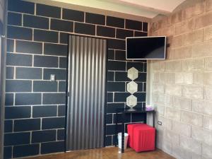 a room with a door with a television and a red suitcase at CÁLIDO COSMOS HOTEL in Cholula
