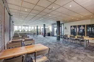a large room with tables and chairs and windows at Abrigall Hostel Masella in La Masella