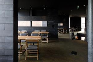 comedor con mesas y sillas de madera en GALLERIA MIDOBARU en Beppu