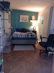 1 dormitorio con 1 cama y 1 silla en una habitación en Loft Estudio El Faro - Zona Estero Beach, en Ensenada