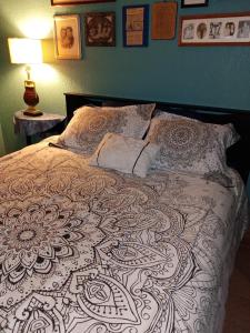 a bedroom with a bed with a black and white blanket at Loft Estudio El Faro - Zona Estero Beach in Ensenada