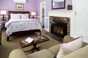 肯尼邦克港的住宿－1802 House Bed & Breakfast，一间卧室配有一张床和一个壁炉
