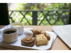 einen Teller mit einem Ei und einer Tasse Kaffee und Gebäck in der Unterkunft R&B Hotel Kobe Motomachi - Vacation STAY 15387v in Kōbe
