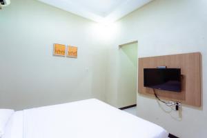 A television and/or entertainment centre at Ardhya Guesthouse Syariah by ecommerceloka