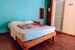 Ce lit se trouve dans une chambre dotée d'un mur bleu. dans l'établissement Hotel Lekami, à Puerto Escondido