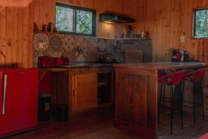 a kitchen with wooden cabinets and a red refrigerator at Cabaña Oma in Puerto Iguazú