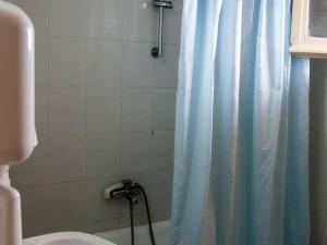 a bathroom with a shower with a blue shower curtain at Apraos Bay Hotel In Kalamaki Beach in Apraos