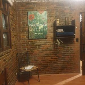 a brick wall with a chair and a sign on it at Cerca del Colmex, Flacso y U Pedagogica in Mexico City