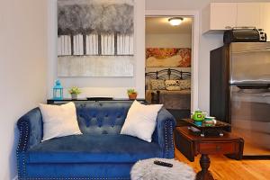 ein blaues Sofa im Wohnzimmer mit einem Tisch in der Unterkunft Ottawa Downtown Executive Apartment Retreat with Private Balcony near Bank Street - Sleep Max 2 in Ottawa