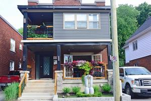 ein Haus mit einem Balkon mit Blumen darauf in der Unterkunft Ottawa Downtown Executive Apartment Retreat with Private Balcony near Bank Street - Sleep Max 2 in Ottawa