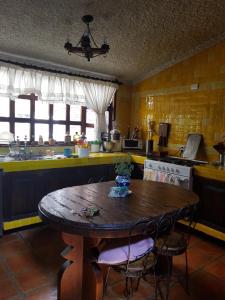 een keuken met een houten tafel met stoelen en een tafel bij Cerca del Colmex, Flacso y U Pedagogica in Mexico-Stad