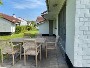 Une table et des chaises en bois sont disponibles sur la terrasse. dans l'établissement Beau Sejour, à Heuvelland