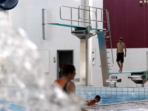 Ein Mann steht auf einem Sprungbrett in einem Schwimmbad. in der Unterkunft 6 person holiday home in Sk rb k in Skærbæk