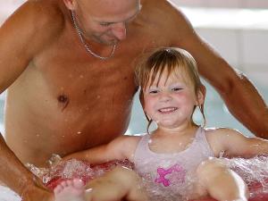 un hombre y un niño pequeño en una bañera en 6 person holiday home in Sk rb k, en Skærbæk