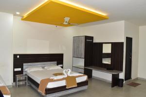 sypialnia z łóżkiem i żółtym sufitem w obiekcie Dharwad Residency w mieście Dharwad