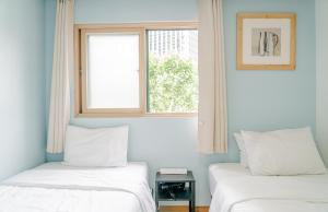 two beds in a room with a window at For family group, 4min to Seoul station in Seoul