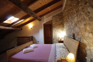 1 dormitorio con 1 cama en una pared de piedra en Casa Vacanze Antico Poggio, en Poggio San Giovanni