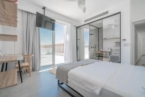 a bedroom with a bed and a desk and a balcony at Danielle boutique suite in Caesarea