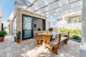 a patio with a wooden table and benches at Villa Stone Pearl in Sutivan