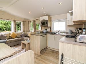 a caravan kitchen and living room with a couch at Ochenta in Combe Martin