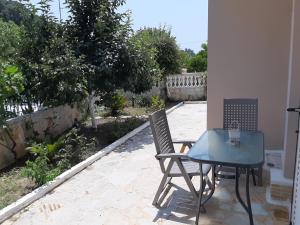 eine Terrasse mit einem Tisch und 2 Stühlen auf einer Terrasse in der Unterkunft Villa Pappas in Parga