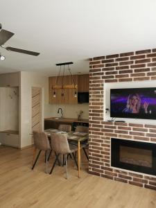 a living room with a brick fireplace with a table and chairs at trendy in Ventspils