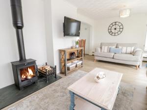 a living room with a fireplace and a couch at Gorwelion in Holyhead