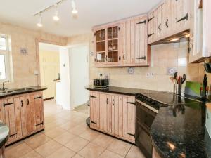 a kitchen with wooden cabinets and black counter tops at Gorwelion in Holyhead