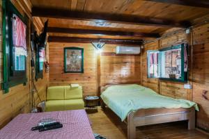 ein kleines Schlafzimmer mit einem Bett und einem Stuhl in der Unterkunft Vajat BB in Bajina Bašta